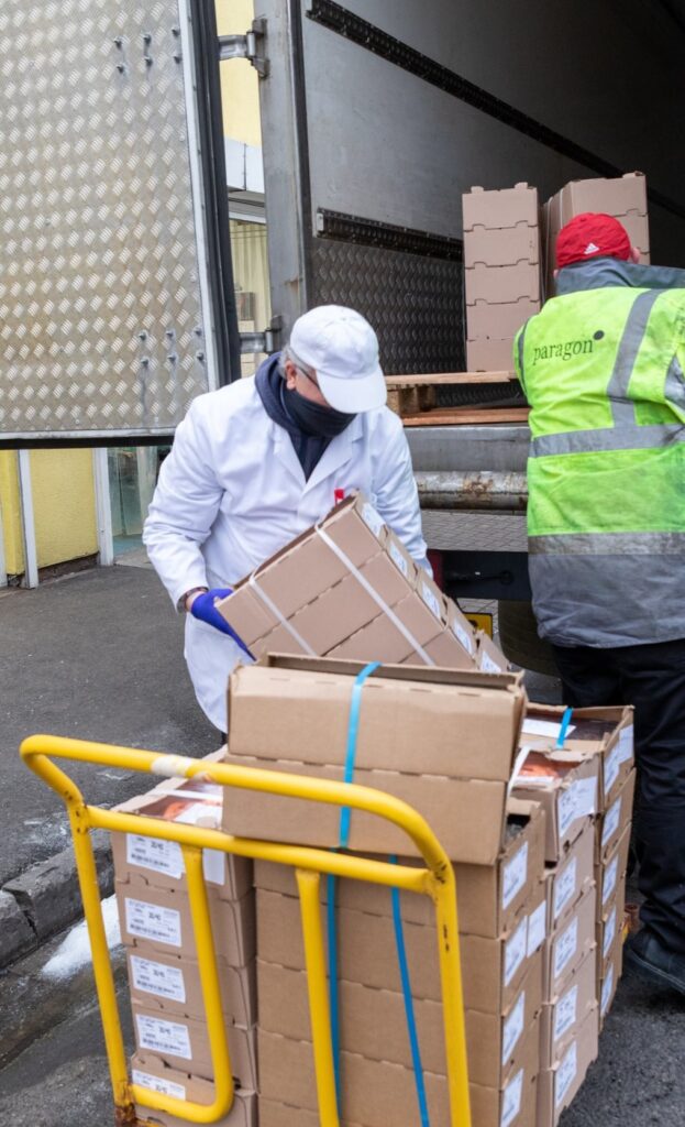 Fishmonger loading delivery boxes onto a pallet trolley